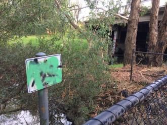 Illegible graffitied EPA sign by drain