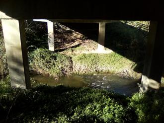 View under bridge looking east across creek