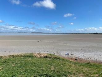 The lake was 'half empty.' The water was a long way from shore. The dry surface had a grey appearance.